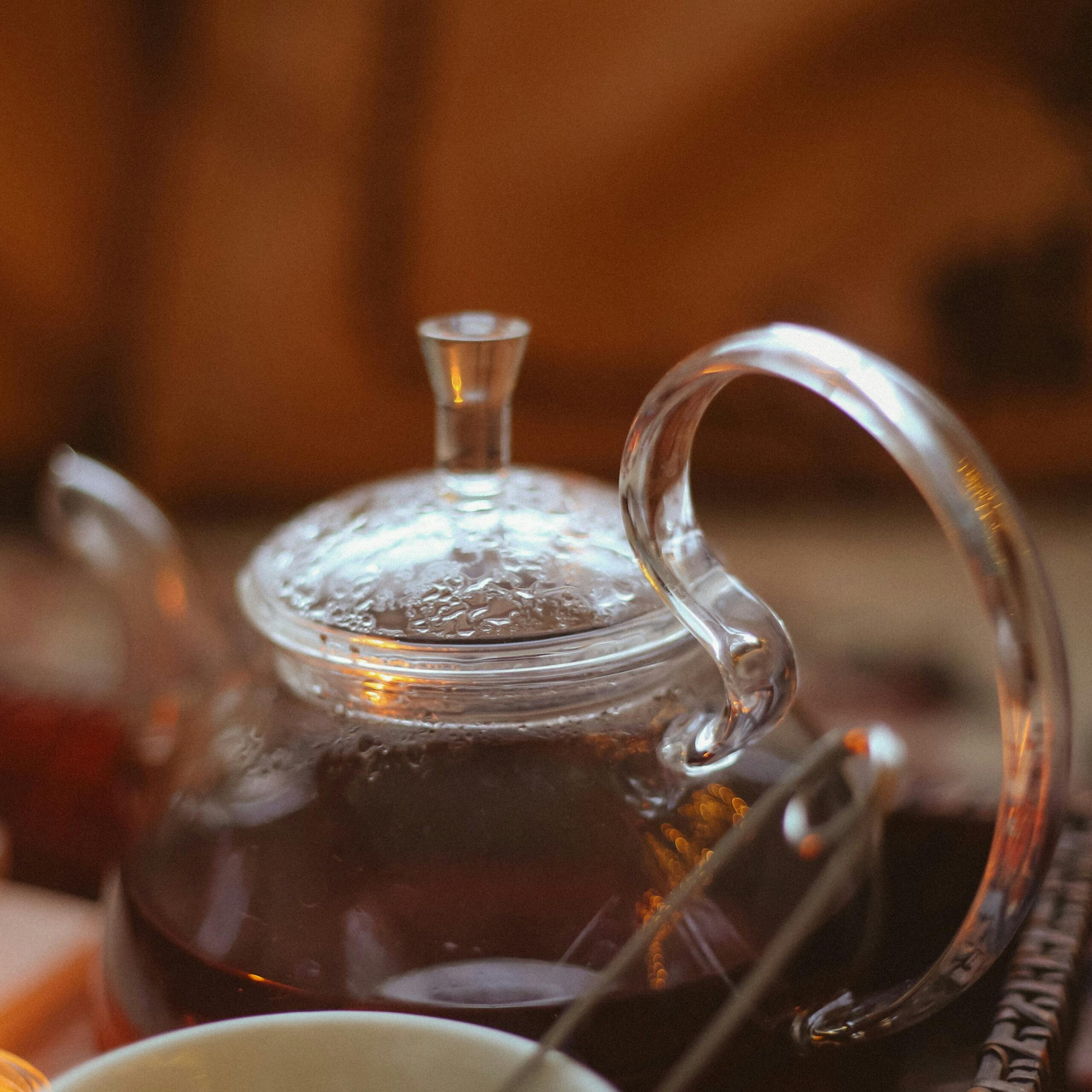 Elegant glass teapot with steaming tea, creating a cozy atmosphere. Perfect for lifestyle and culinary art.