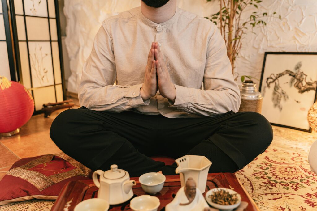 A serene tea ceremony with a man practicing mindfulness indoors.