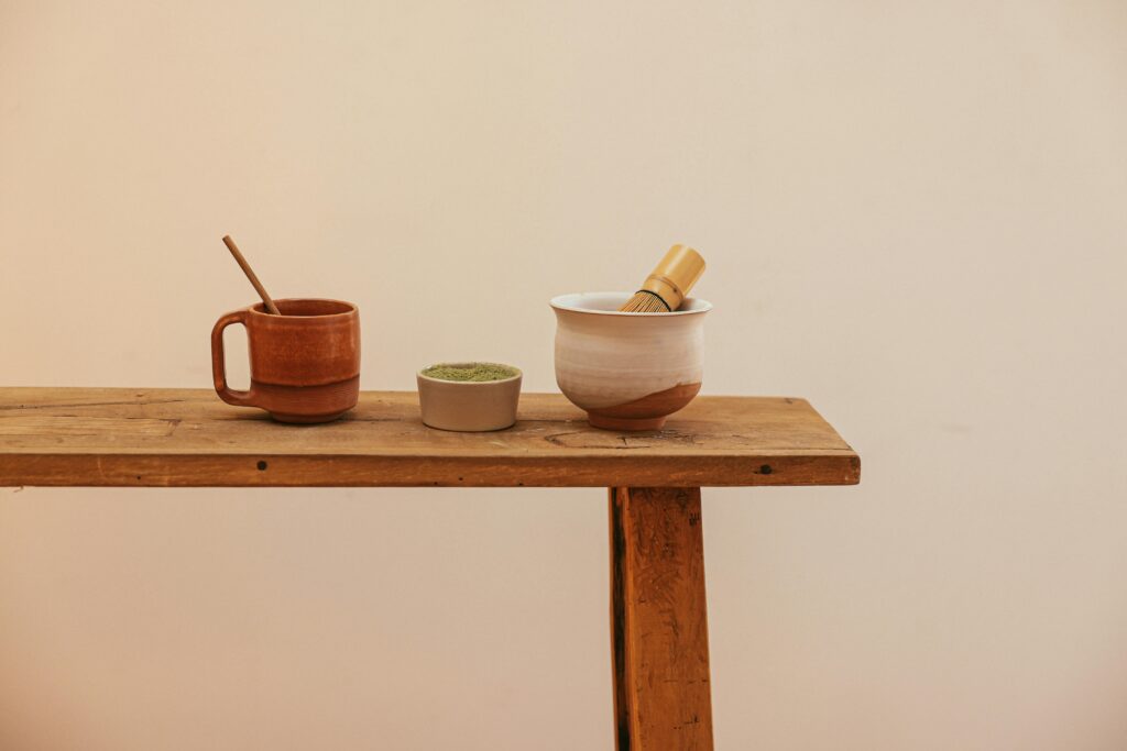 A minimalist setup of matcha tea tools on a wooden table, perfect for serene tea moments.