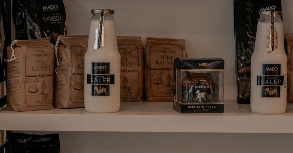 Neatly arranged pantry shelves with glass bottles and coffee bags.