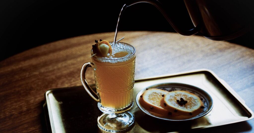 A refreshing citrus cocktail served in a glass with orange slices, perfect for a cozy setting.