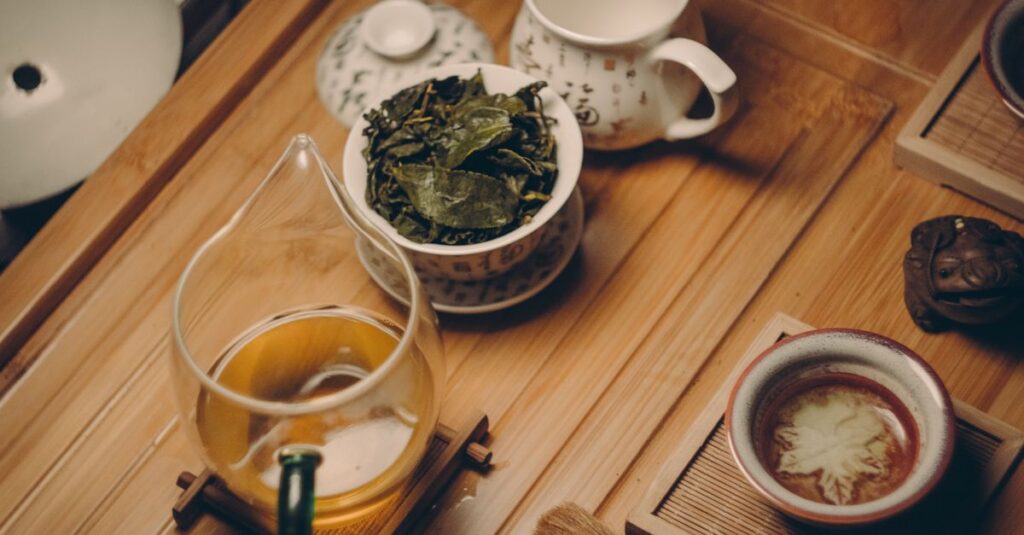 Warm, inviting tea ceremony scene with traditional teapot, leaves, and cup on a wooden table.