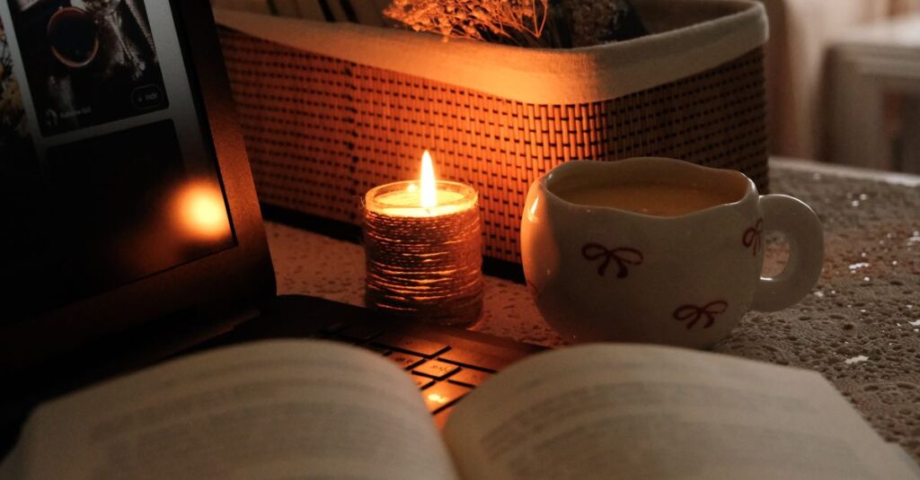 Warm and cozy evening scene with candlelight, a cup of drink, and an open book.
