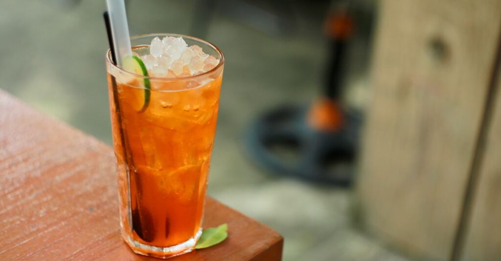 Chilled glass of iced tea with lime on a sunny day. Perfect for summer vibes.