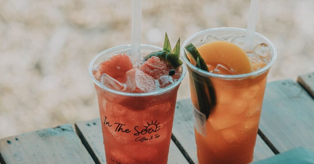 Two iced summer drinks on a wooden table, perfect for outdoor refreshment.