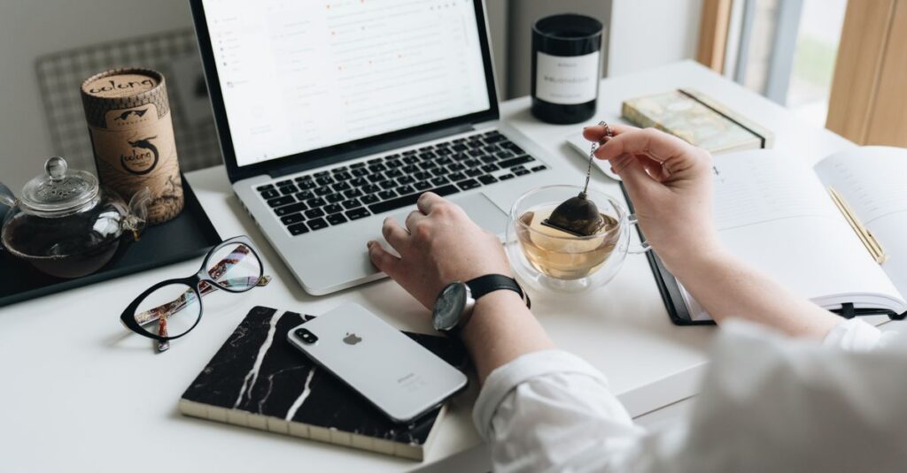 A cozy home office scene with a laptop, tea, and workspace essentials.