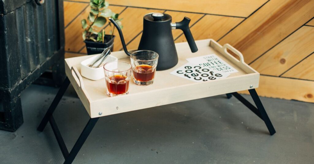 Modern folding table setup with teapot and coffee for a cozy indoor atmosphere.