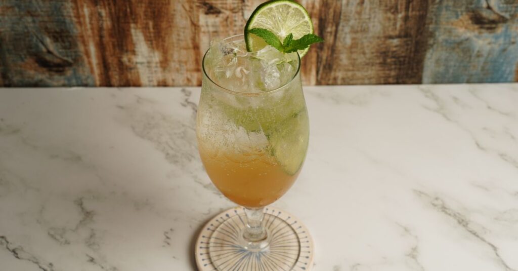 A refreshing iced drink with lime and mint, served on a marble table. Perfect for cooling down.