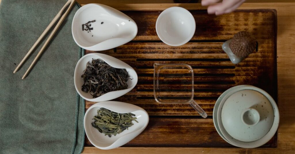 Elegant top view of a traditional tea set with various tea leaves and accessories.