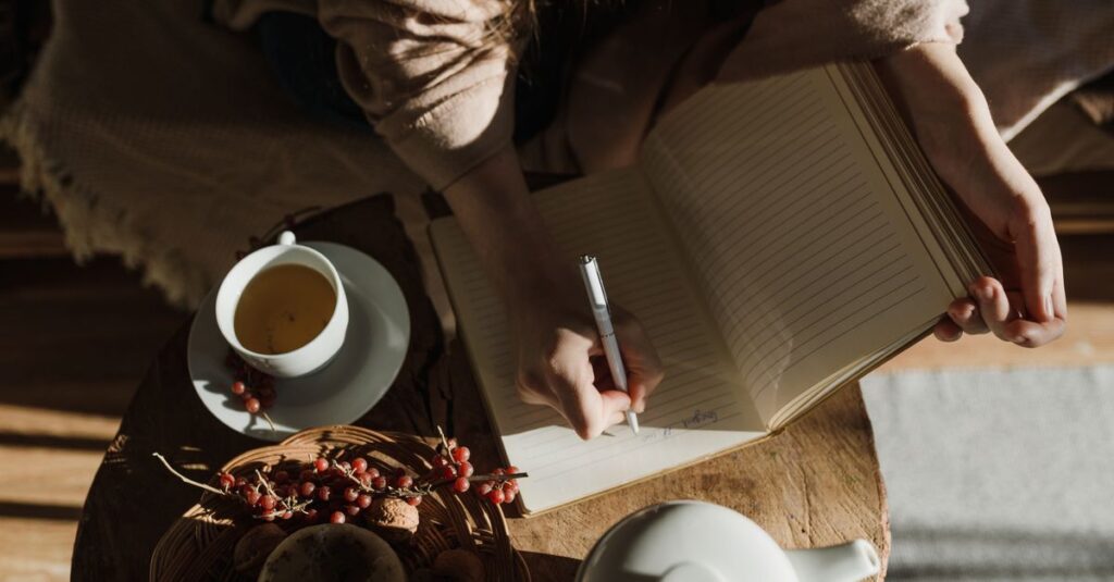 A peaceful scene of a person writing notes in a cozy setting with tea.