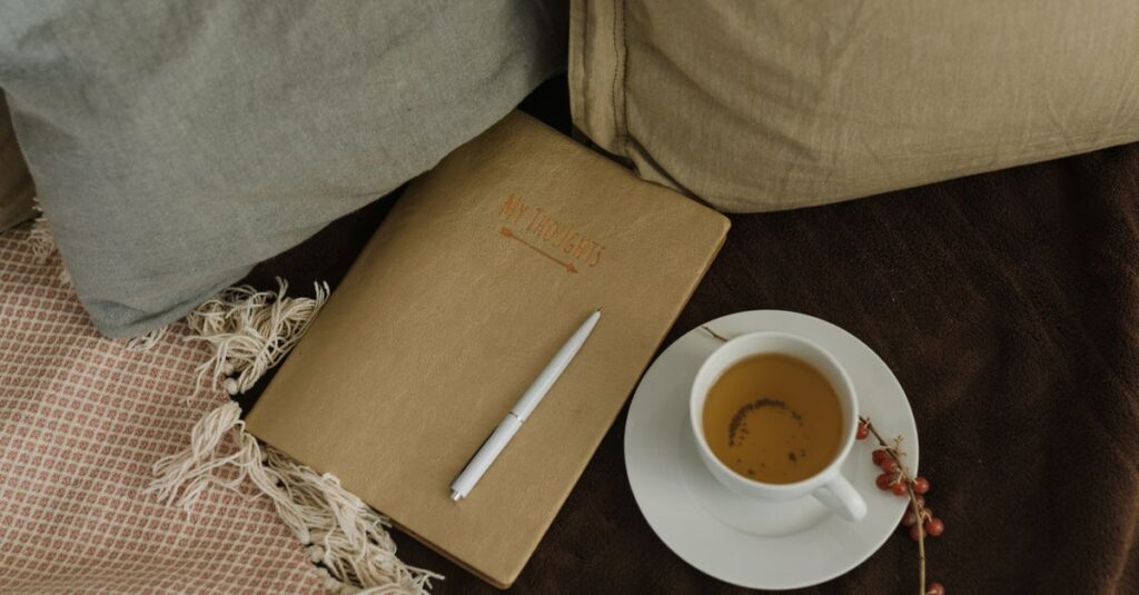 Comfortable scene with a hot drink, notebook, pen, and cozy fabric. Perfect for relaxation.