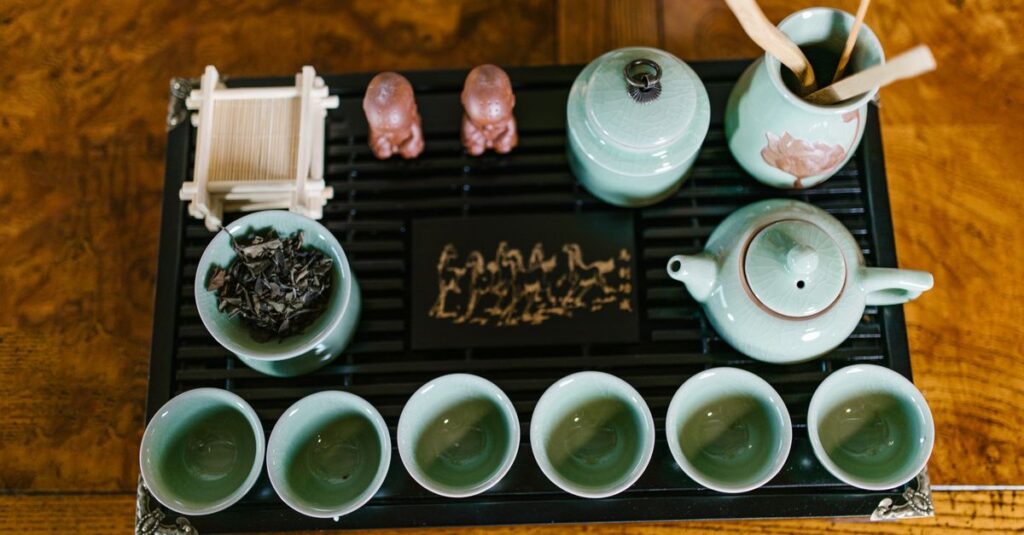 Top view of a traditional tea set with accessories on a wooden surface.
