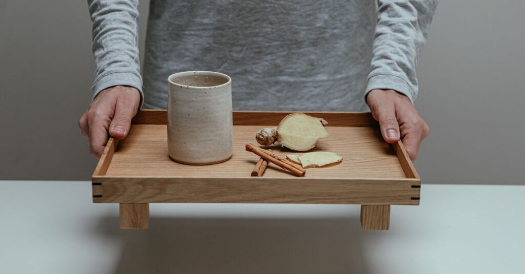 Minimalist setup featuring a serving tray with ginger and cinnamon sticks. Perfect for natural wellness themes.