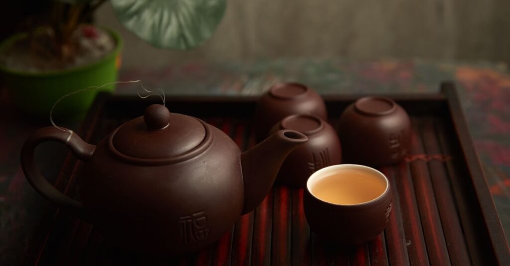 Elegant display of a traditional tea set on a wooden tray reflecting a serene tea ceremony ambiance.