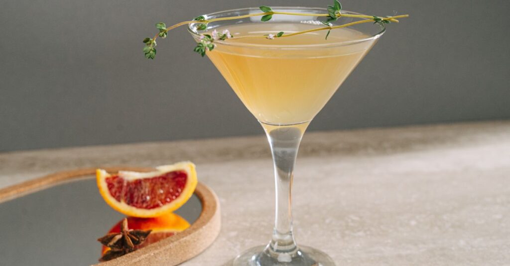 Elegant grapefruit cocktail in a martini glass, garnished with fresh herbs, perfect for a refreshing drink.