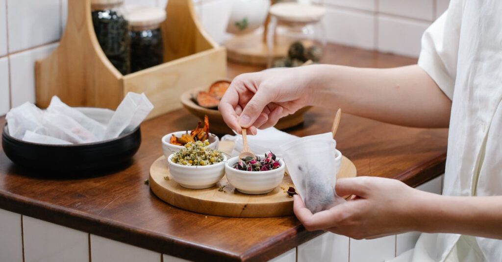 Close-up of hands preparing herbal tea with fresh ingredients in a cozy kitchen.