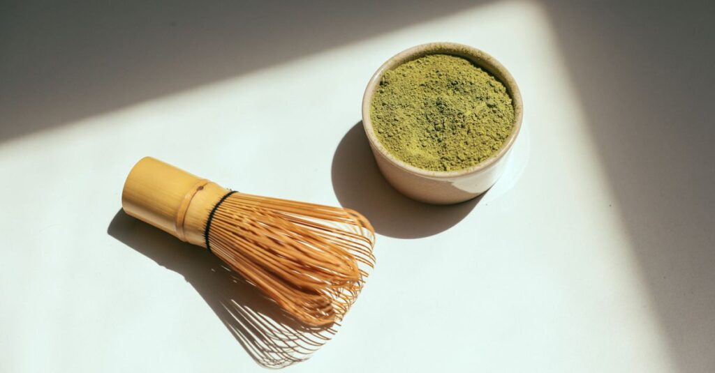 Minimalist composition featuring matcha powder and bamboo whisk in sunlight.