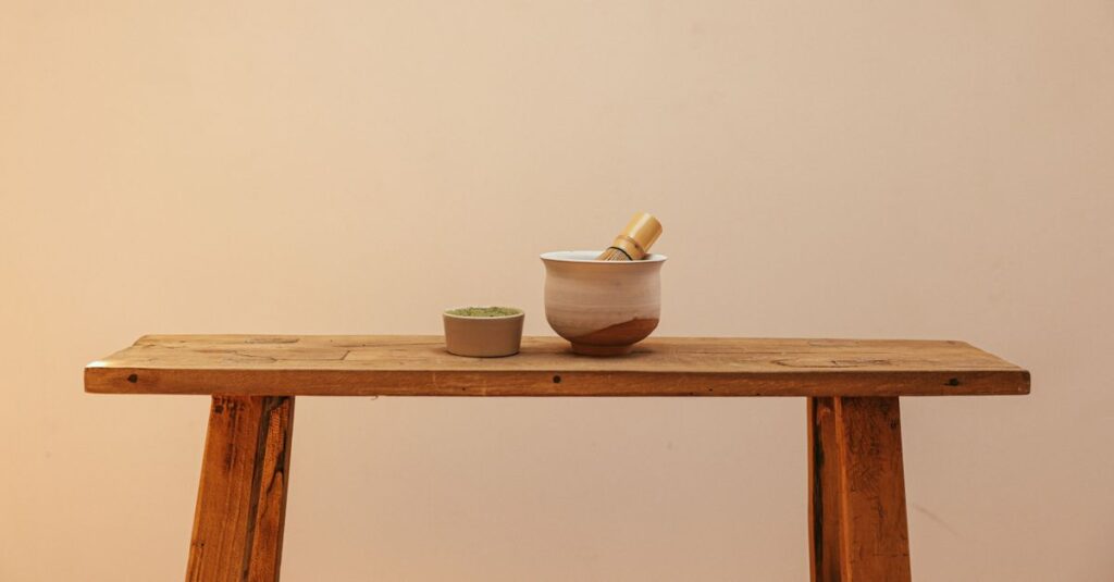Minimalist setup with matcha bowl and whisk on rustic wooden table, ideal for tea enthusiasts.
