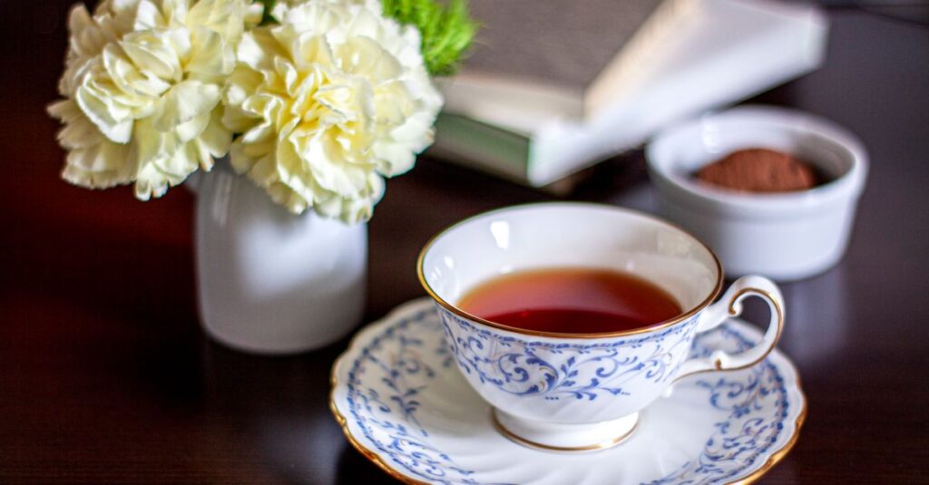 A beautifully arranged tea set with white flowers and a book, creating a cozy atmosphere.