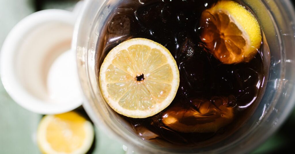Overhead view of iced lemon drink in a clear glass with citrus slices.