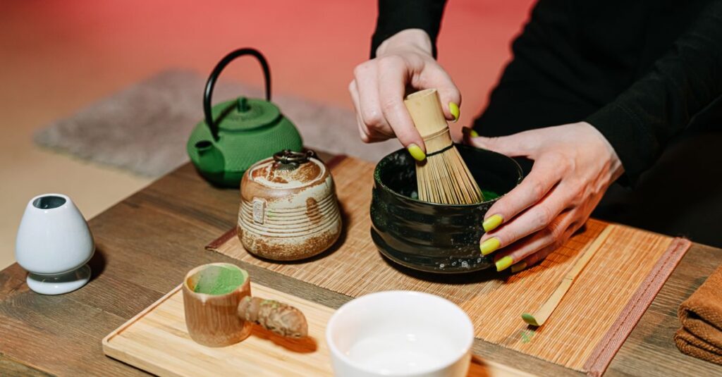 Close-up of hands preparing matcha in a traditional Japanese tea ceremony with utensils.