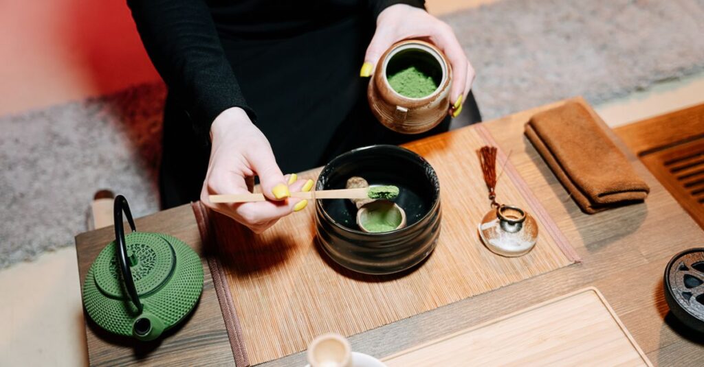 Hands preparing matcha tea in a traditional Japanese ceremony with vibrant green and earthy tones.