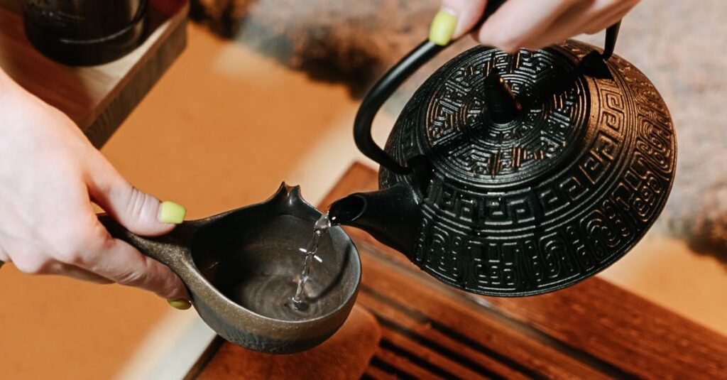 Close-up of a traditional tea ceremony, featuring a decorative teapot pouring into a cup.