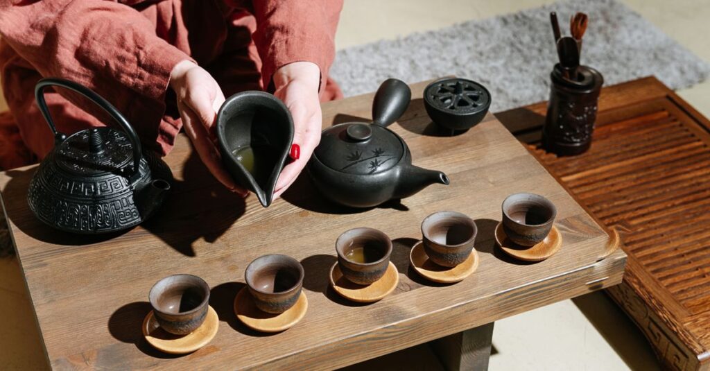 A detailed view of a traditional tea ceremony with clay teapots and cups on a wooden table, showcasing a cultural ritual.